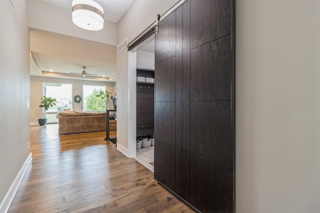 905 NE Badger Ln, Waukee, IA 50263 - hall with a barn door, wood finished floors, and a raised ceiling