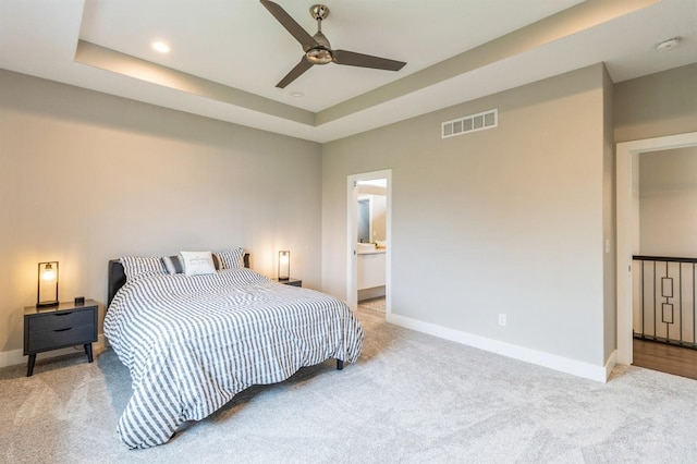 905 NE Badger Ln, Waukee, IA 50263 - bedroom featuring light colored carpet, a ceiling fan, recessed lighting, a tray ceiling, and ensuite bathroom