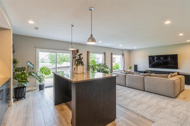 905 NE Badger Ln, Waukee, IA 50263 - kitchen with recessed lighting, light wood-style flooring, a center island, and hanging light fixtures