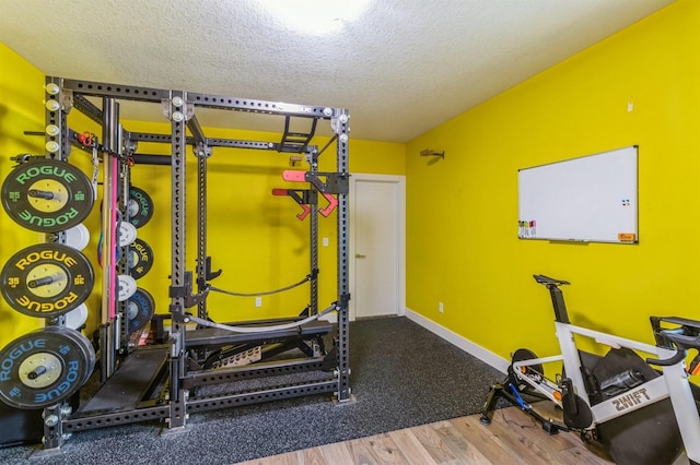 905 NE Badger Ln, Waukee, IA 50263 - exercise area with a textured ceiling and wood finished floors