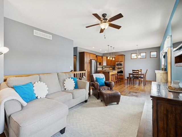 2458 SE 108th St, Runnells, IA 50237 - living room featuring ceiling fan, light wood-type flooring, recessed lighting, and a chandelier