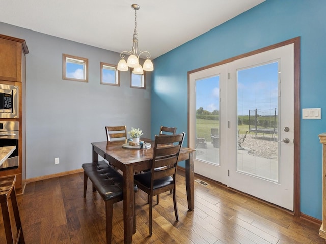 2458 SE 108th St, Runnells, IA 50237 - dining area with a chandelier, healthy amount of natural light, and dark wood-style flooring