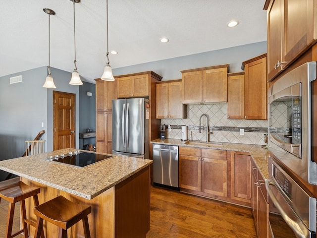 2458 SE 108th St, Runnells, IA 50237 - kitchen with appliances with stainless steel finishes, a center island, tasteful backsplash, brown cabinets, and recessed lighting