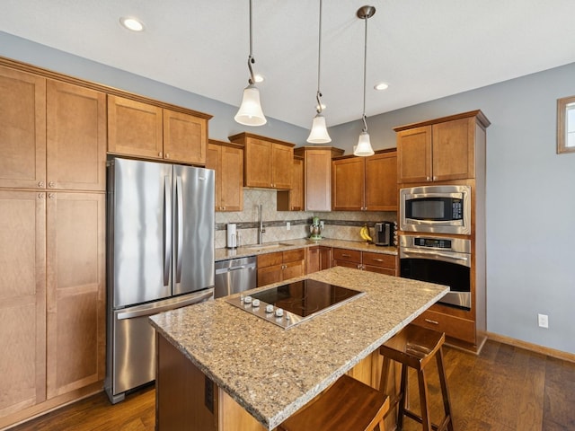 2458 SE 108th St, Runnells, IA 50237 - kitchen with stainless steel appliances, dark wood finished floors, decorative backsplash, a kitchen island, and light stone countertops