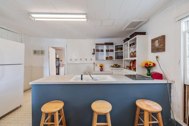 311 E 4th St, Riverside, IA 52327 - kitchen with freestanding refrigerator, light flooring, a peninsula, a breakfast bar, and open shelves