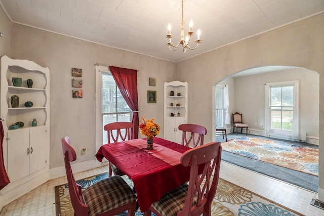 311 E 4th St, Riverside, IA 52327 - dining space featuring arched walkways, a chandelier, crown molding, and light flooring