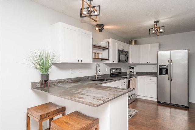 150 S Prairie View Dr Unit 601, West Des Moines, IA 50266 - kitchen with stainless steel appliances, open shelves, white cabinets, a kitchen bar, and a textured ceiling