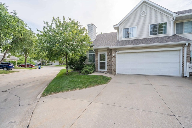 150 S Prairie View Dr Unit 601, West Des Moines, IA 50266 - traditional home with concrete driveway, a chimney, brick siding, roof with shingles, and a front lawn