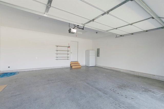 427 Spring Crest Ln, Waukee, IA 50263 - garage with electric panel, a garage door opener, and freestanding refrigerator
