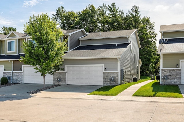 427 Spring Crest Ln, Waukee, IA 50263 - view of front of home with stone siding, a garage, a shingled roof, driveway, and a front yard