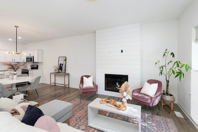 427 Spring Crest Ln, Waukee, IA 50263 - living room featuring wood finished floors, a chandelier, a fireplace, and recessed lighting