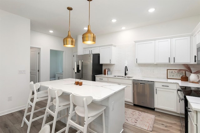 427 Spring Crest Ln, Waukee, IA 50263 - kitchen with stainless steel appliances, tasteful backsplash, light wood-type flooring, white cabinets, and recessed lighting