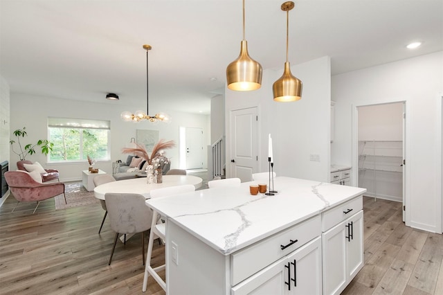 427 Spring Crest Ln, Waukee, IA 50263 - kitchen with light wood finished floors, white cabinets, open floor plan, pendant lighting, and recessed lighting