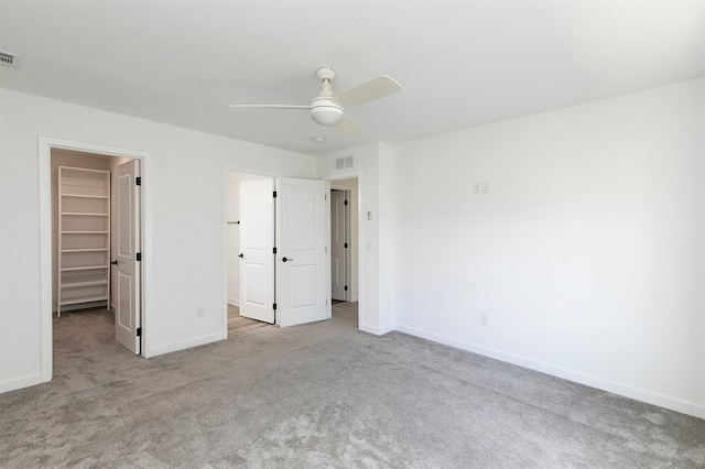 427 Spring Crest Ln, Waukee, IA 50263 - unfurnished bedroom with a walk in closet, carpet flooring, and a ceiling fan