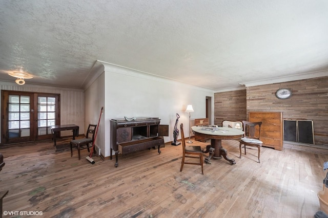 7012 Sunrise Blvd, Windsor Heights, IA 50324 - dining area with crown molding, wood walls, wood finished floors, french doors, and a textured ceiling