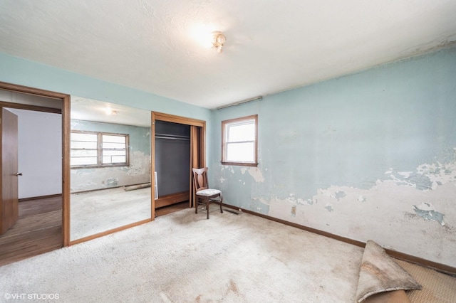 7012 Sunrise Blvd, Windsor Heights, IA 50324 - unfurnished bedroom with a closet, multiple windows, and carpet floors
