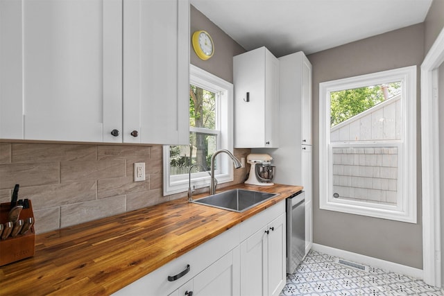 3315 61st St, Des Moines, IA 50322 - kitchen featuring wood counters, healthy amount of natural light, and white cabinets