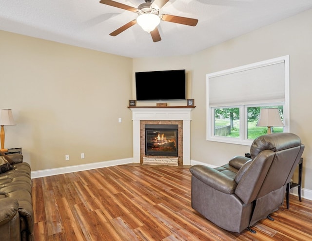 929 Sampson Dr, Nevada, IA 50201 - living room featuring wood finished floors, a ceiling fan, and a tiled fireplace