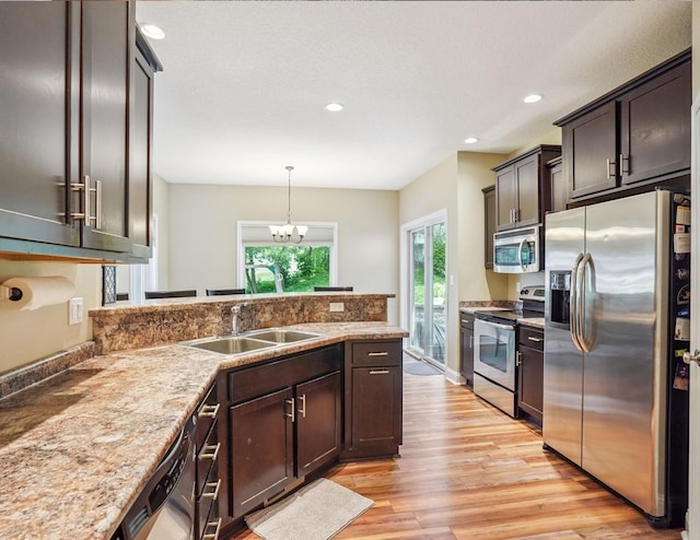 929 Sampson Dr, Nevada, IA 50201 - kitchen featuring appliances with stainless steel finishes, light wood-style flooring, a peninsula, recessed lighting, and a chandelier