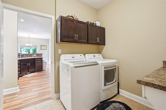 929 Sampson Dr, Nevada, IA 50201 - washroom featuring cabinet space, washer and dryer, light tile patterned flooring, a chandelier, and recessed lighting