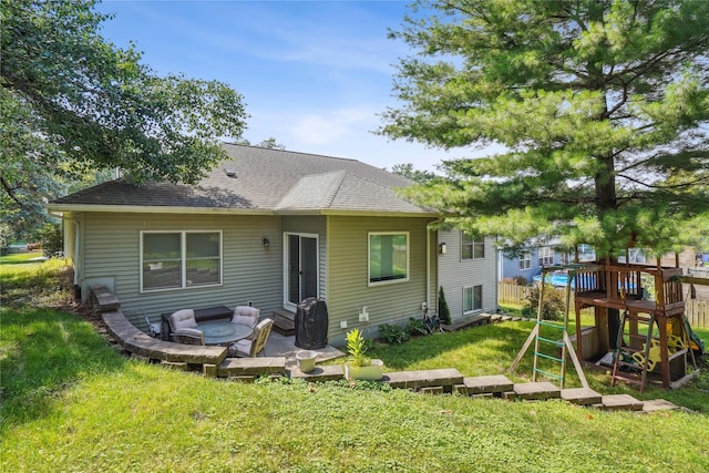 929 Sampson Dr, Nevada, IA 50201 - rear view of house featuring a lawn, a patio, roof with shingles, a playground, and an outdoor living space