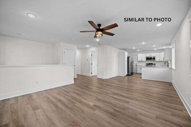 2517 Shaw St, Des Moines, IA 50317 - unfurnished living room featuring ceiling fan, light wood-style floors, and recessed lighting