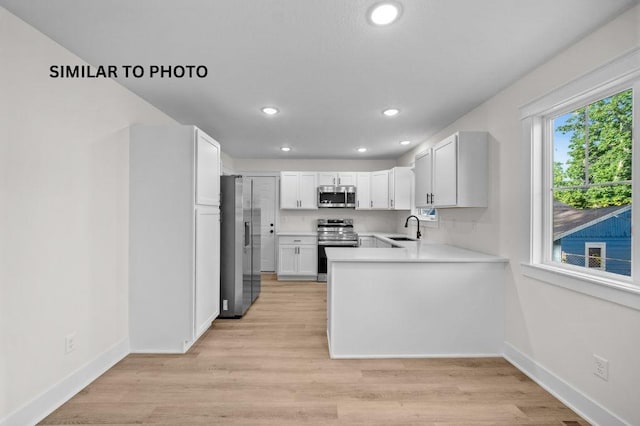 2517 Shaw St, Des Moines, IA 50317 - kitchen featuring appliances with stainless steel finishes, light countertops, recessed lighting, a peninsula, and white cabinets