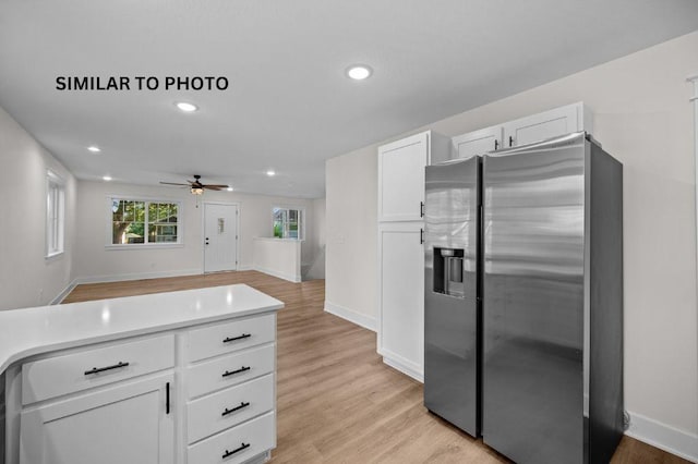 2517 Shaw St, Des Moines, IA 50317 - kitchen with stainless steel fridge, white cabinets, recessed lighting, ceiling fan, and light wood finished floors