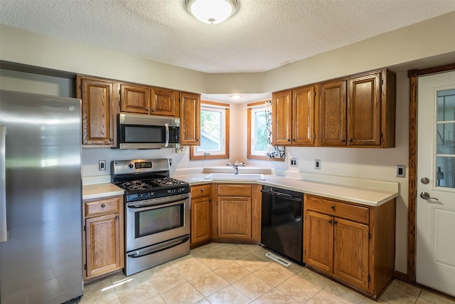 4624 Tamara Ln, West Des Moines, IA 50265 - kitchen featuring stainless steel appliances, a textured ceiling, brown cabinetry, light countertops, and light tile patterned floors