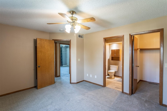 4624 Tamara Ln, West Des Moines, IA 50265 - unfurnished bedroom featuring carpet floors, a walk in closet, a textured ceiling, ensuite bath, and ceiling fan