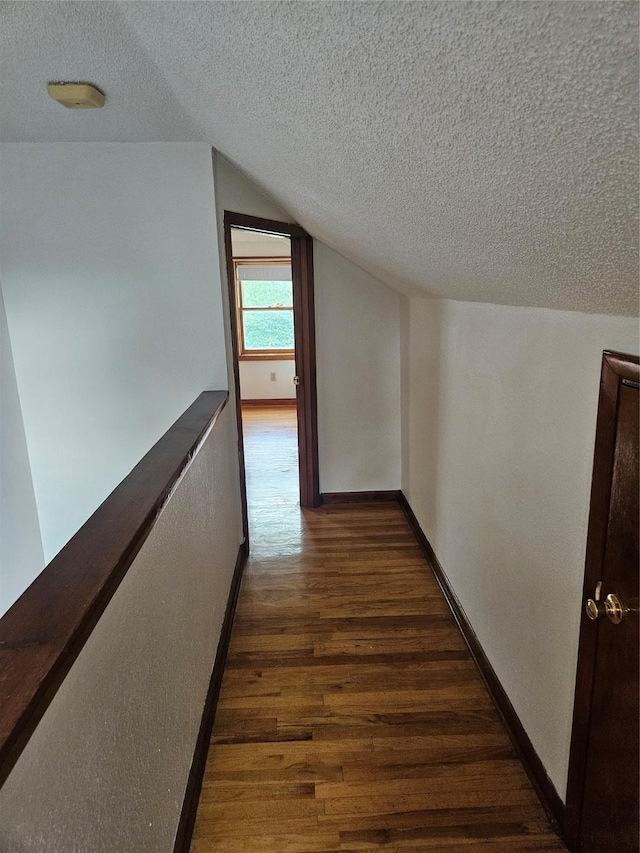 4690 Hubbell Ave, Des Moines, IA 50317 - hallway featuring a textured ceiling, dark wood-type flooring, and vaulted ceiling