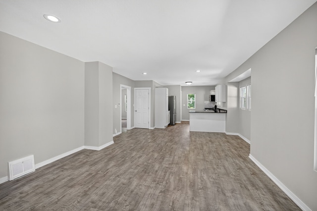 1728 NW Dr, Des Moines, IA 50310 - unfurnished living room with wood finished floors and recessed lighting