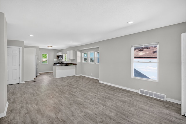 1728 NW Dr, Des Moines, IA 50310 - unfurnished living room featuring wood finished floors and recessed lighting