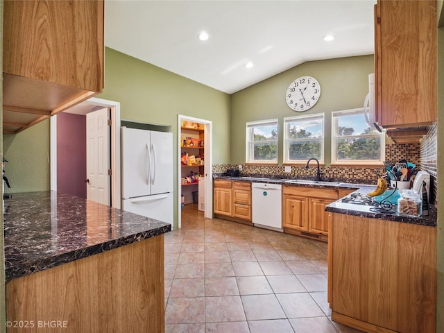623 N Main St, Stuart, IA 50250 - kitchen with white appliances, lofted ceiling, tasteful backsplash, light tile patterned flooring, and dark stone counters