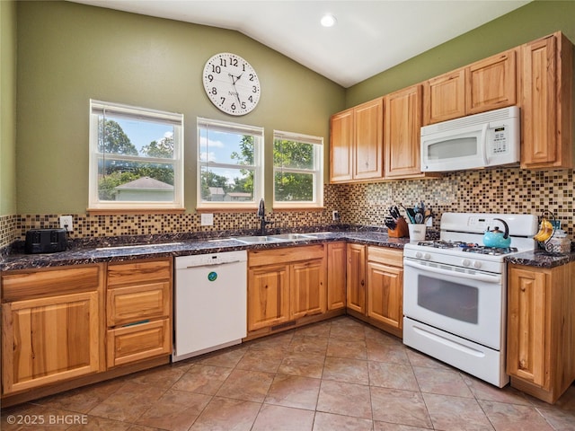 623 N Main St, Stuart, IA 50250 - kitchen featuring white appliances, decorative backsplash, lofted ceiling, dark stone counters, and light tile patterned floors
