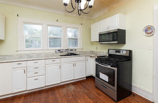 1118 Euclid Ave, Des Moines, IA 50313 - kitchen with stainless steel appliances, a chandelier, white cabinets, and dark wood finished floors