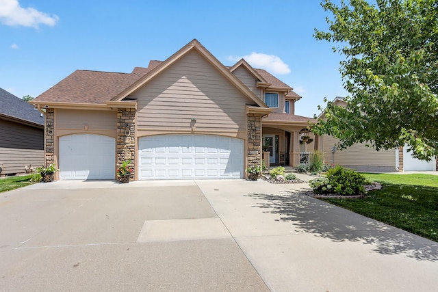 4309 129th St, Urbandale, IA 50323 - view of front of house featuring a garage, concrete driveway, stone siding, and roof with shingles