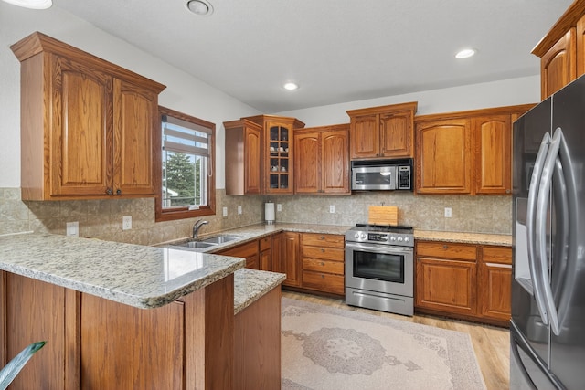 4309 129th St, Urbandale, IA 50323 - kitchen with appliances with stainless steel finishes, a peninsula, brown cabinetry, and recessed lighting
