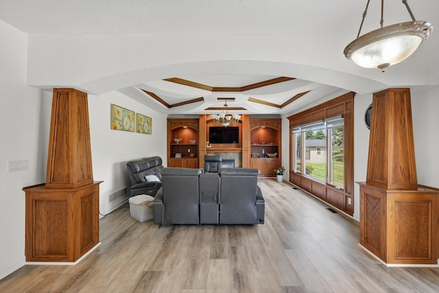 4309 129th St, Urbandale, IA 50323 - living area with arched walkways, light wood-type flooring, a tray ceiling, and a chandelier