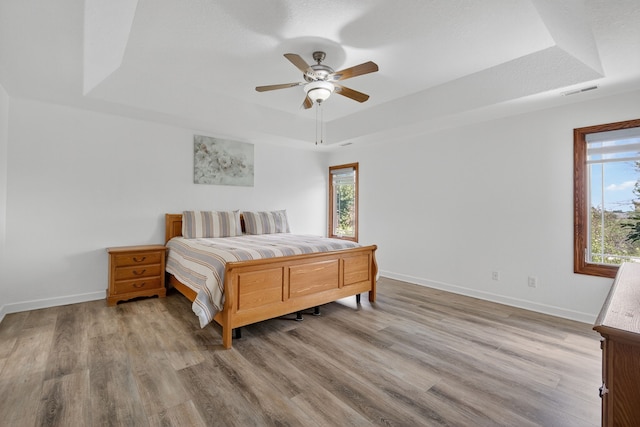 4309 129th St, Urbandale, IA 50323 - bedroom with a raised ceiling, multiple windows, wood finished floors, and ceiling fan