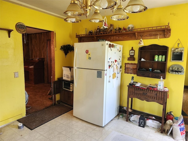 503 Main St, Harvey, IA 50119 - kitchen featuring freestanding refrigerator, tile patterned floors, and a chandelier