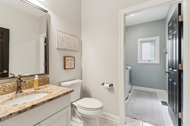 7016 Harbour Dr, Johnston, IA 50131 - bathroom featuring washer and clothes dryer, vanity, and tile patterned floors