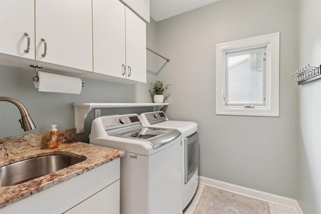 7016 Harbour Dr, Johnston, IA 50131 - laundry area featuring washing machine and dryer, cabinet space, and light tile patterned floors