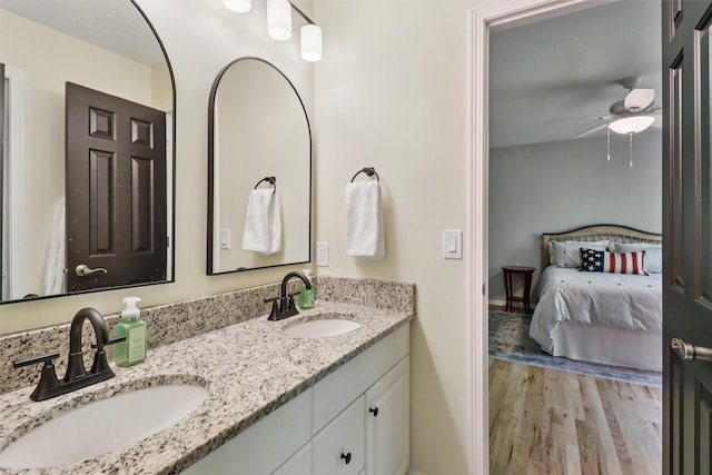 7016 Harbour Dr, Johnston, IA 50131 - bathroom featuring double vanity, wood finished floors, connected bathroom, and ceiling fan