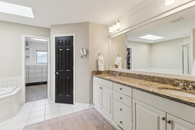 7016 Harbour Dr, Johnston, IA 50131 - bathroom with a skylight, tile patterned flooring, double vanity, a walk in closet, and a garden tub