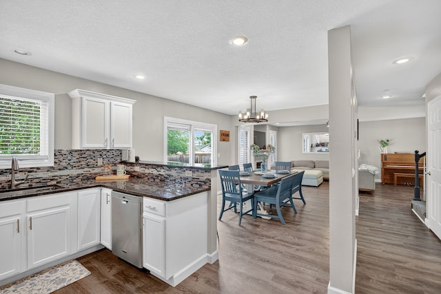 4808 Dewey Pl, Johnston, IA 50131 - kitchen featuring stainless steel dishwasher, a peninsula, dark wood finished floors, a chandelier, and white cabinets