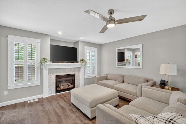 4808 Dewey Pl, Johnston, IA 50131 - living room with healthy amount of natural light, wood finished floors, a ceiling fan, and a glass covered fireplace
