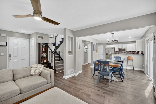 4808 Dewey Pl, Johnston, IA 50131 - dining room with stairs, a chandelier, light wood-style floors, a ceiling fan, and recessed lighting