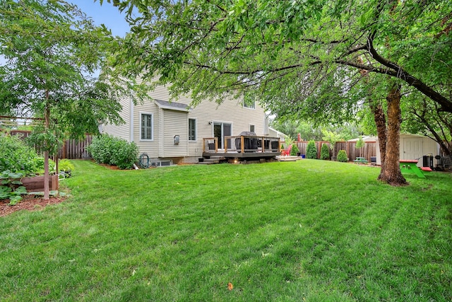 4808 Dewey Pl, Johnston, IA 50131 - fenced backyard featuring a wooden deck and a storage unit