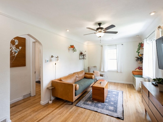1655 NW Dr, Des Moines, IA 50310 - living room with arched walkways, light wood-style flooring, and a ceiling fan